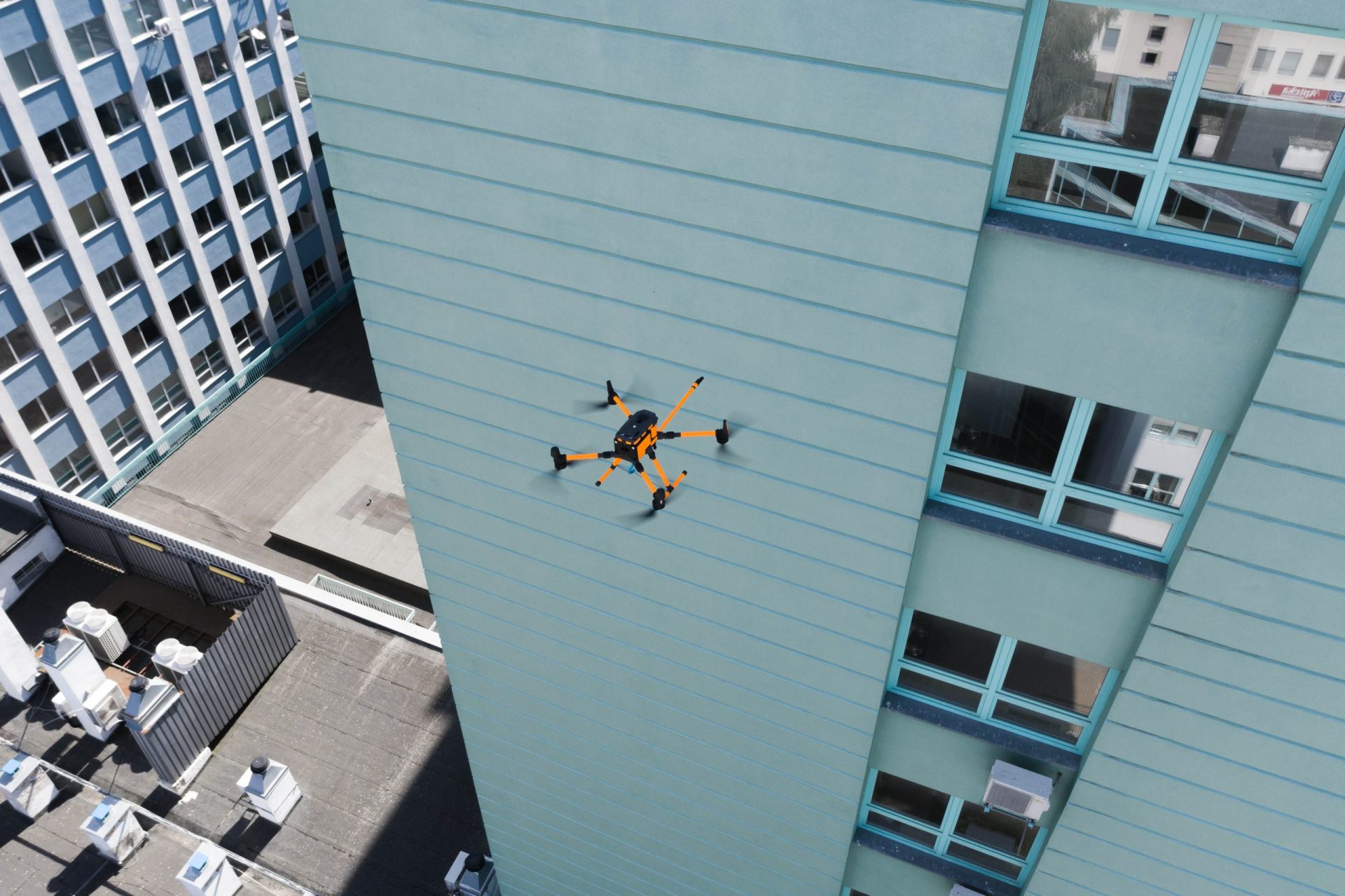 Dron myjący elewację budynku z powietrza